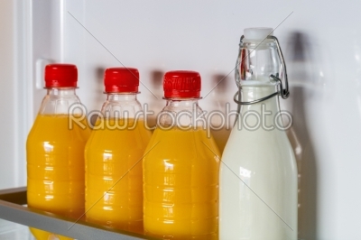 Open fridge filled with orange juice and milk
