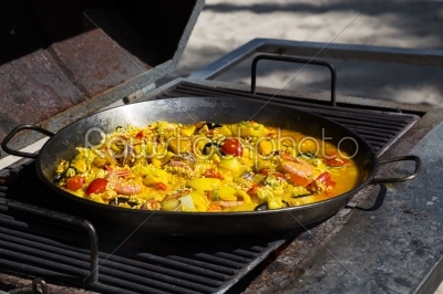 Paella is cooked on a grill