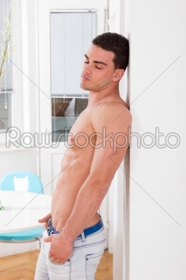 pensive handsome man with naked torso posing recumbent