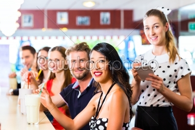 People in American diner or restaurant with milk shakes