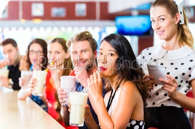 People in American diner or restaurant with milk shakes