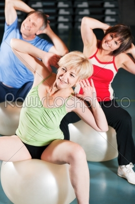 People in gym on exercise ball