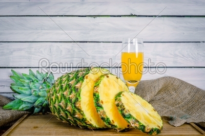 Pineapple and juice on a wooden board