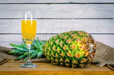Pineapple and juice on a wooden table