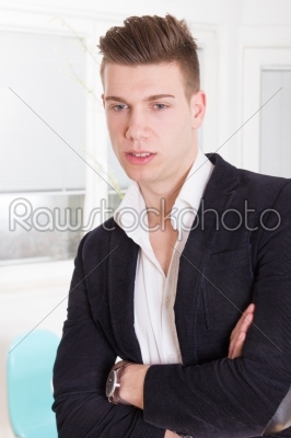 Portrait of a handsome fashionable man posing in the interior