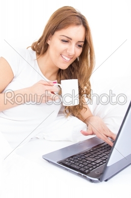 portrait of beautiful woman using laptop holding cup of coffee