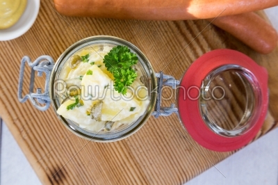 Potato salad in a jar on wooden board