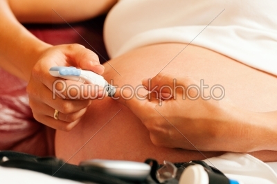 Pregnant woman testing glucose for diabetes