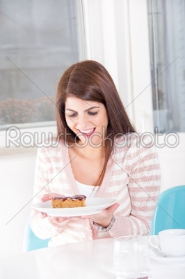 pretty woman looking sweet dessert on the table with smile