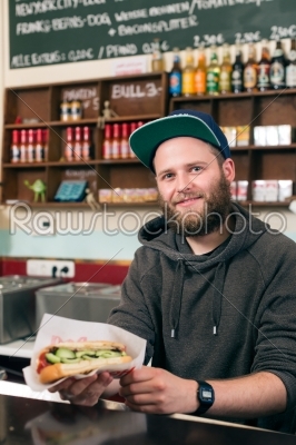 salesman with hotdog in fast food snack bar