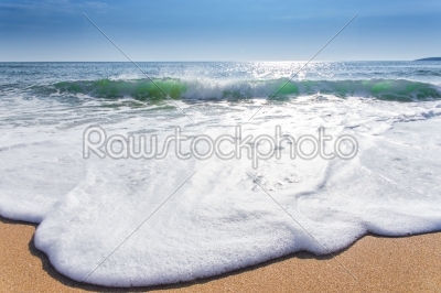 sand sea beach and blue sky after sunrise and splash of seawater