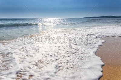 sand sea beach and blue sky after sunrise and splash of seawater
