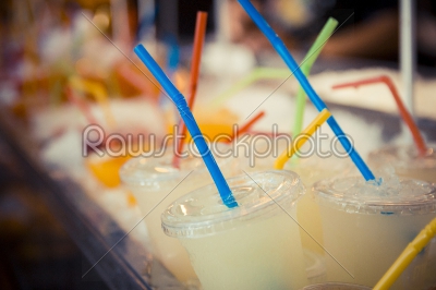 Selection of plastic cups with grapefruit juice and colored stra