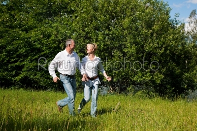 Senior Couple running on a meadow
