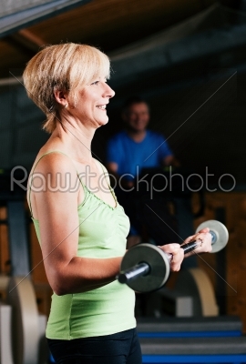 Senior Woman with barbell in gym