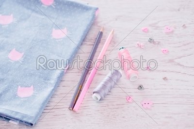 sewing materials, pencils, fabric on a blue and pink color