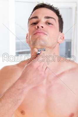 sexy man shaving his beard with razor