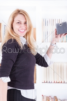 smiling cute casual woman rearranges the shelf