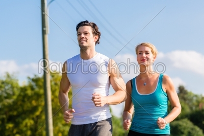 Sport couple running and jogging on rural street