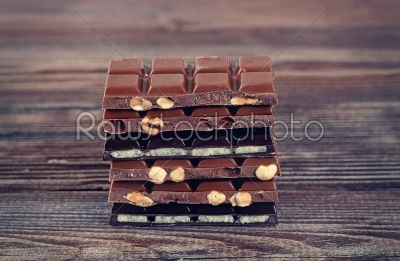 Stack of dark and milk chocolates on wooden table