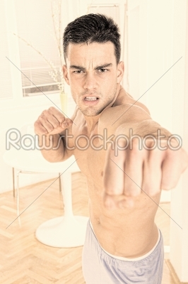 strong angry handsome man fighter punching towards camera