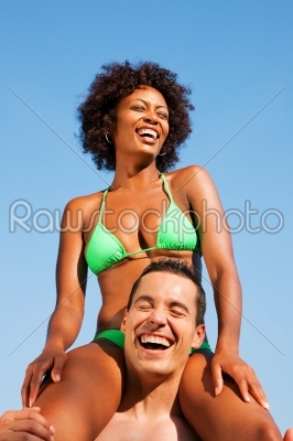 Summer bikini girl sitting on shoulders of man