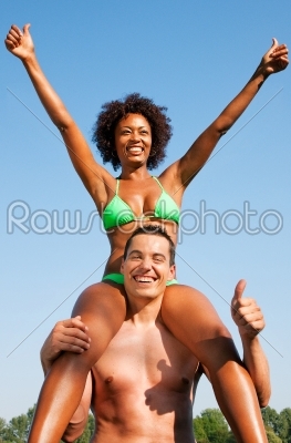 Summer bikini girl sitting on shoulders of man