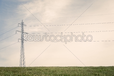 Tall pylons on a green field