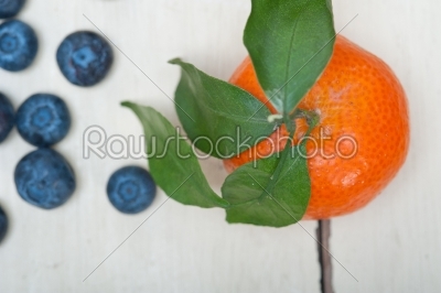 tangerine and blueberry on white table