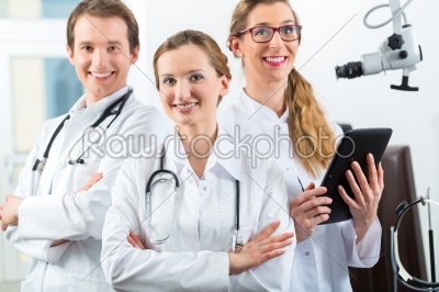 Team of young doctors in clinic with tablet computer