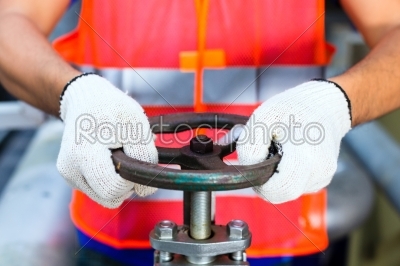 Technician working on valve in factory