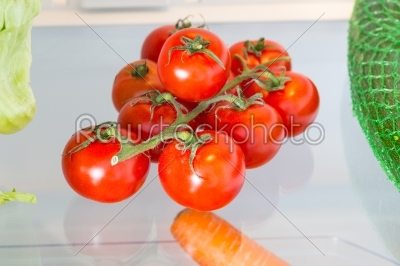 Tomatoes in the refrigerator with the door open