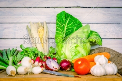 Vegetables on a wooden table with a knife