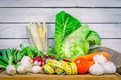 Vegetables on a wooden table with measure tape