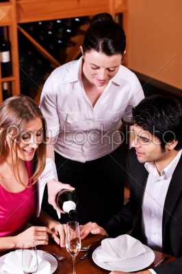 Waitress filling glasses with champagne