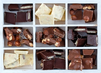 white box with set of chocolates on wooden table isolated