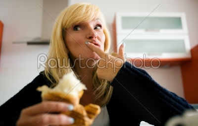Woman eating croissant