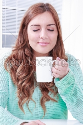 woman enjoying the smell of coffee in the morning