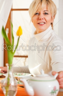 Woman taking cookies from coffee table