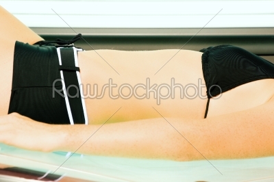 Woman tanning in solarium