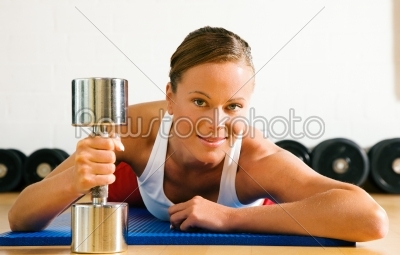 Woman with dumb bell in the gym