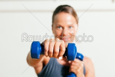 Woman with dumbbell in gym
