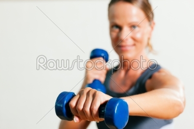 Woman with dumbbell in gym