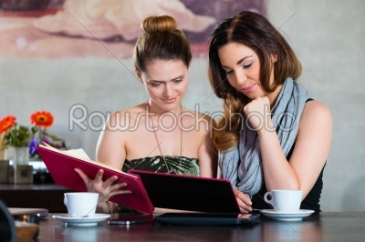 Women in restaurant choosing foor in menu
