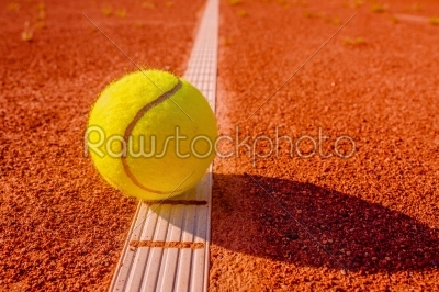 Yellow tennis ball touching the line