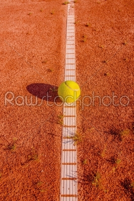 Yellow tennisball on a old court