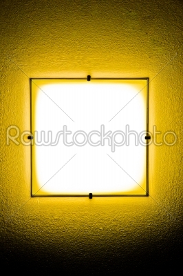 Yellow wall lamp in the darkness