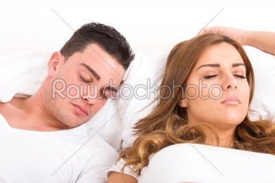 Young beautiful couple sleeping in bed