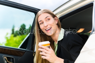 Young businesswoman getting out of taxi
