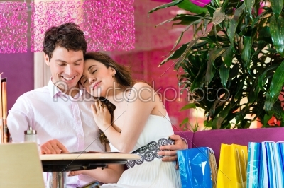 Young couple enjoying coffee after shopping